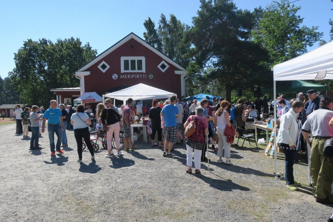 Kuva vuoden 2019 Särkisalo-päiviltä. Taustalla Meripirtin kerho, edustalla paljon ihmisiä aurinkoisessa säässä.