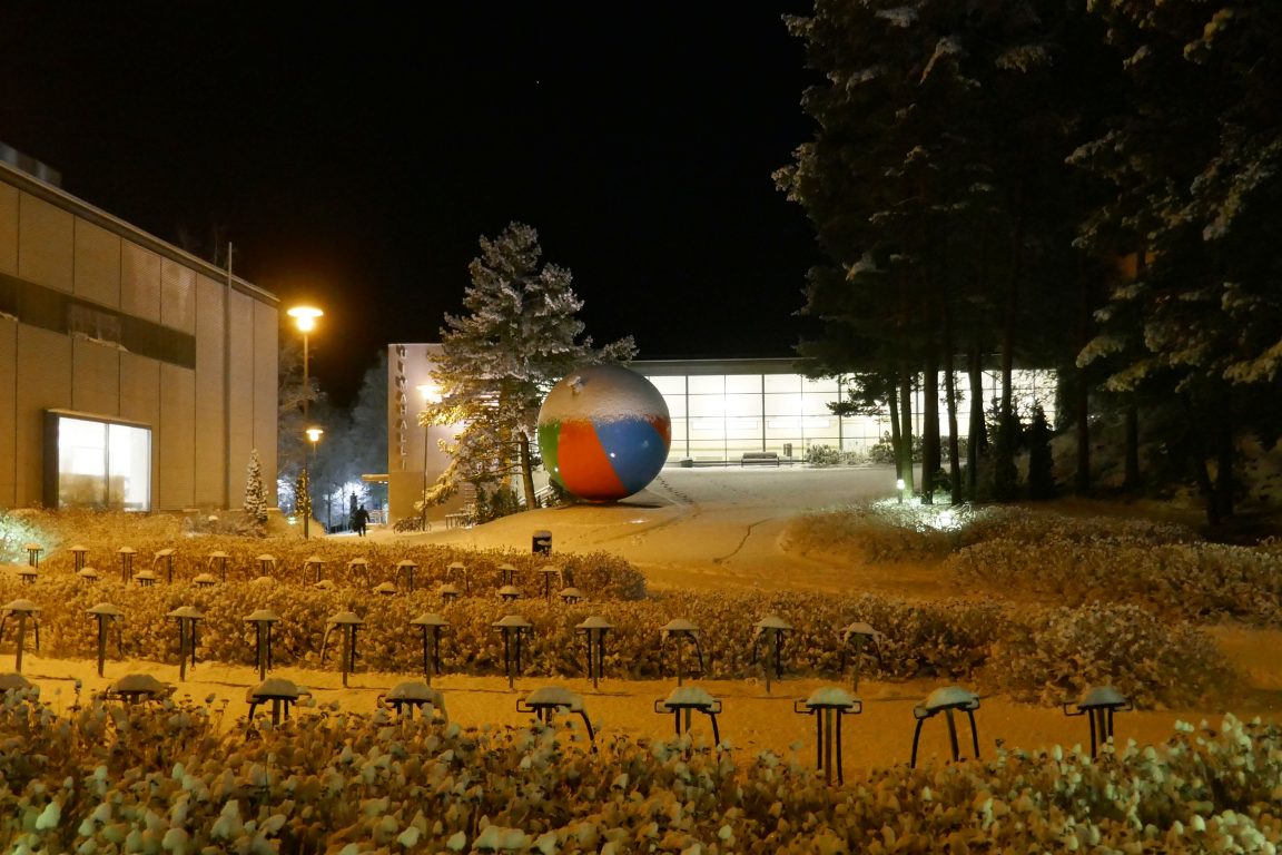 Kuvassa uimahalli lumisessa maisemassa ja Pekka Jylhän iso rantapallo teos 