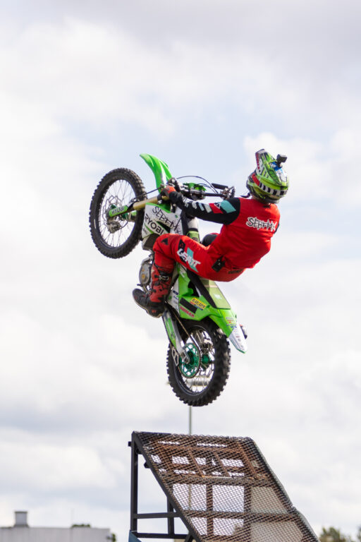 Stunt-hyppääjä lähdössä hyppyristä moottoripyörällä kohti taivasta.