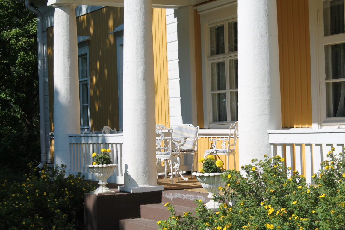 A yellow farmhouse with white columns