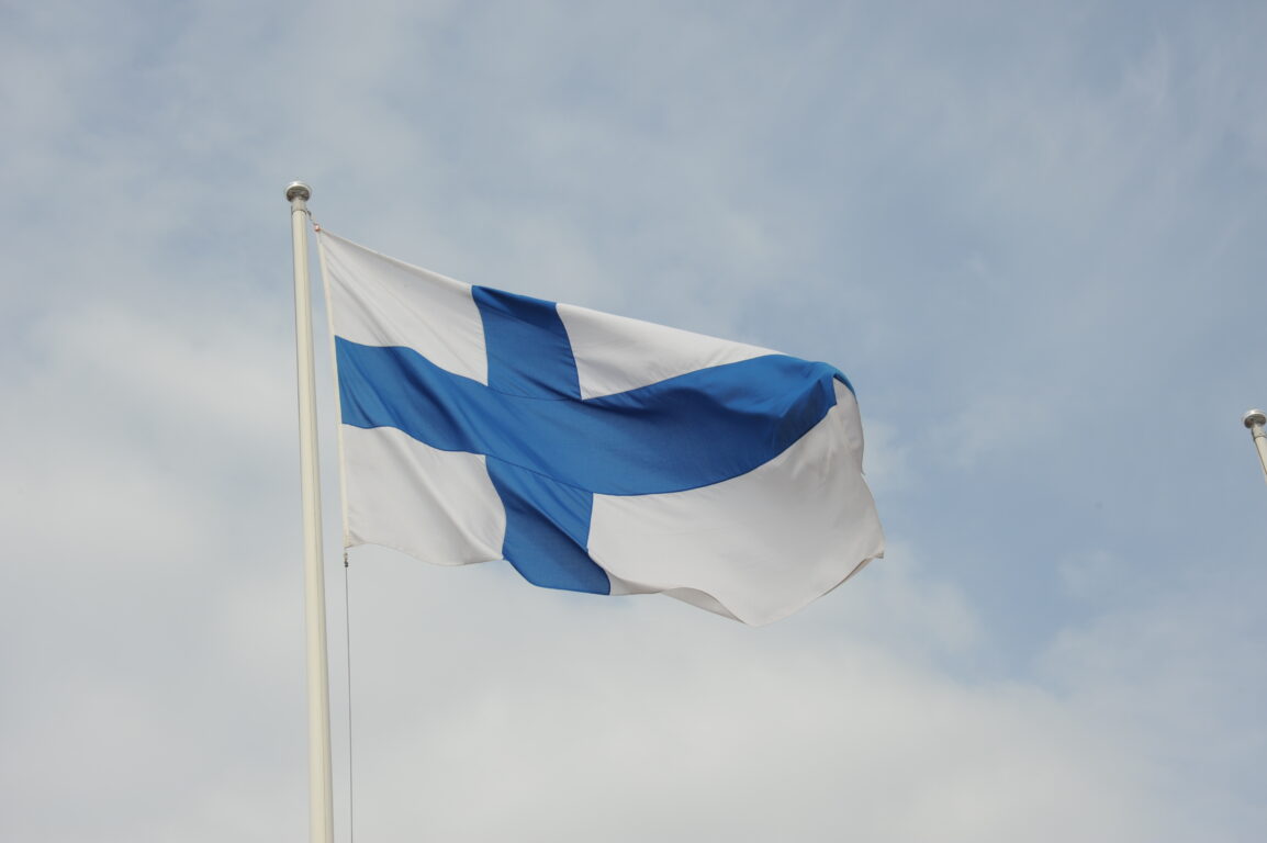 Suomen lippu liehumassa lipputangossa.
