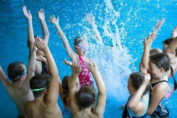 Kuvassa lapsia roiskuttamassa vettä uimahallin altaassa. 