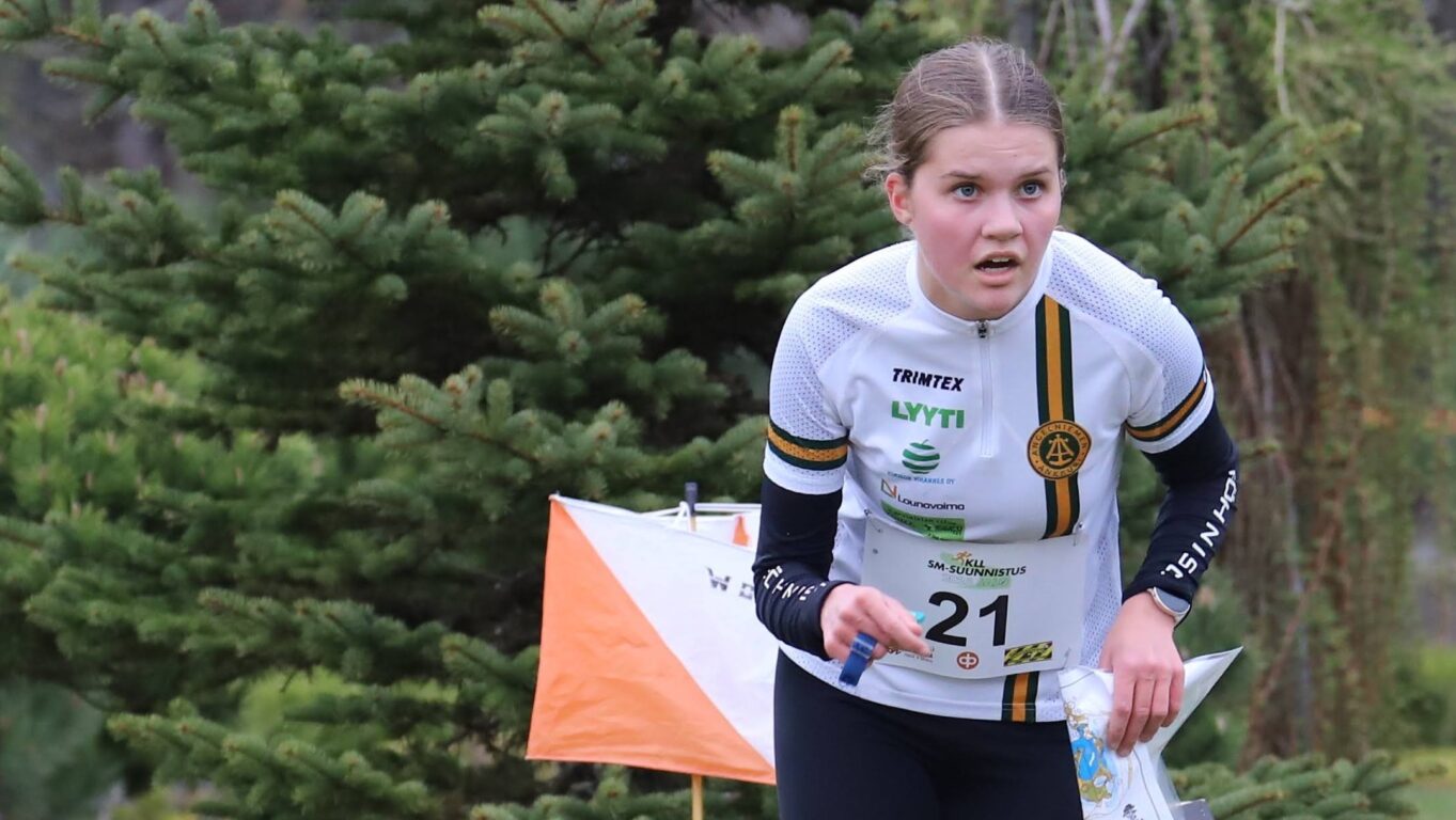 Nuori suunnistajanainen lähdössä suunniistusrastilta eteenpäin.