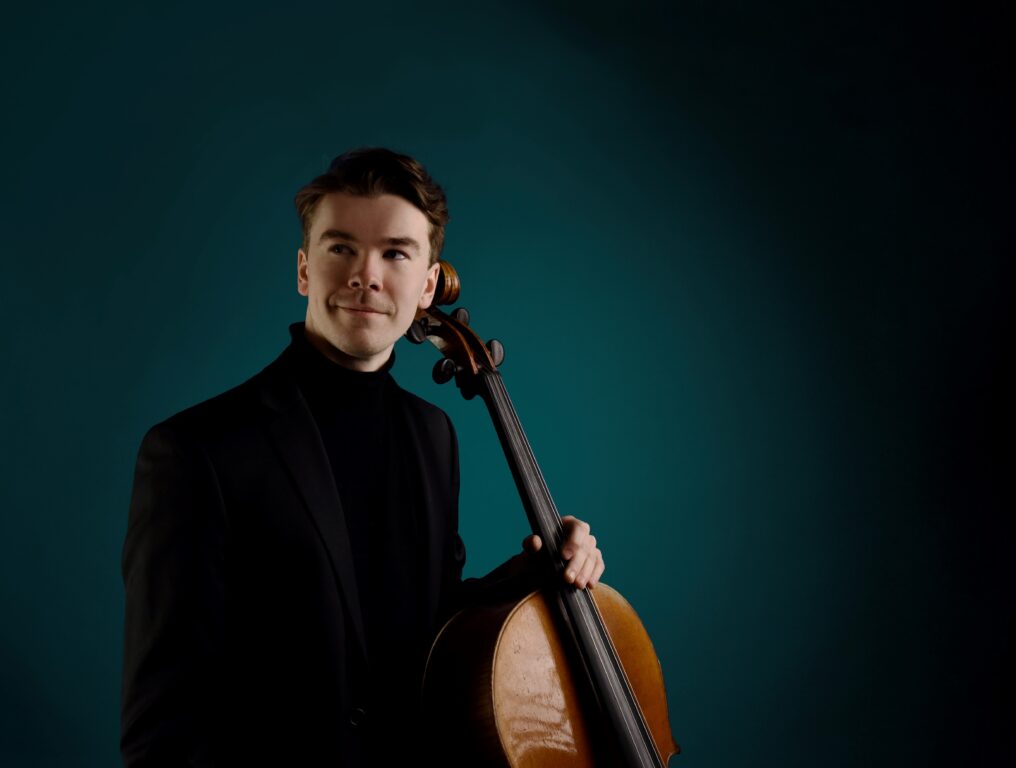 soittaja sellon kanssa, vihreä tausta