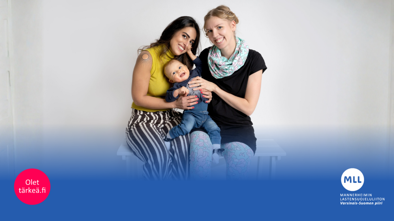 Kaksi naista istuvat tuolilla, pieni lapsi sylissä