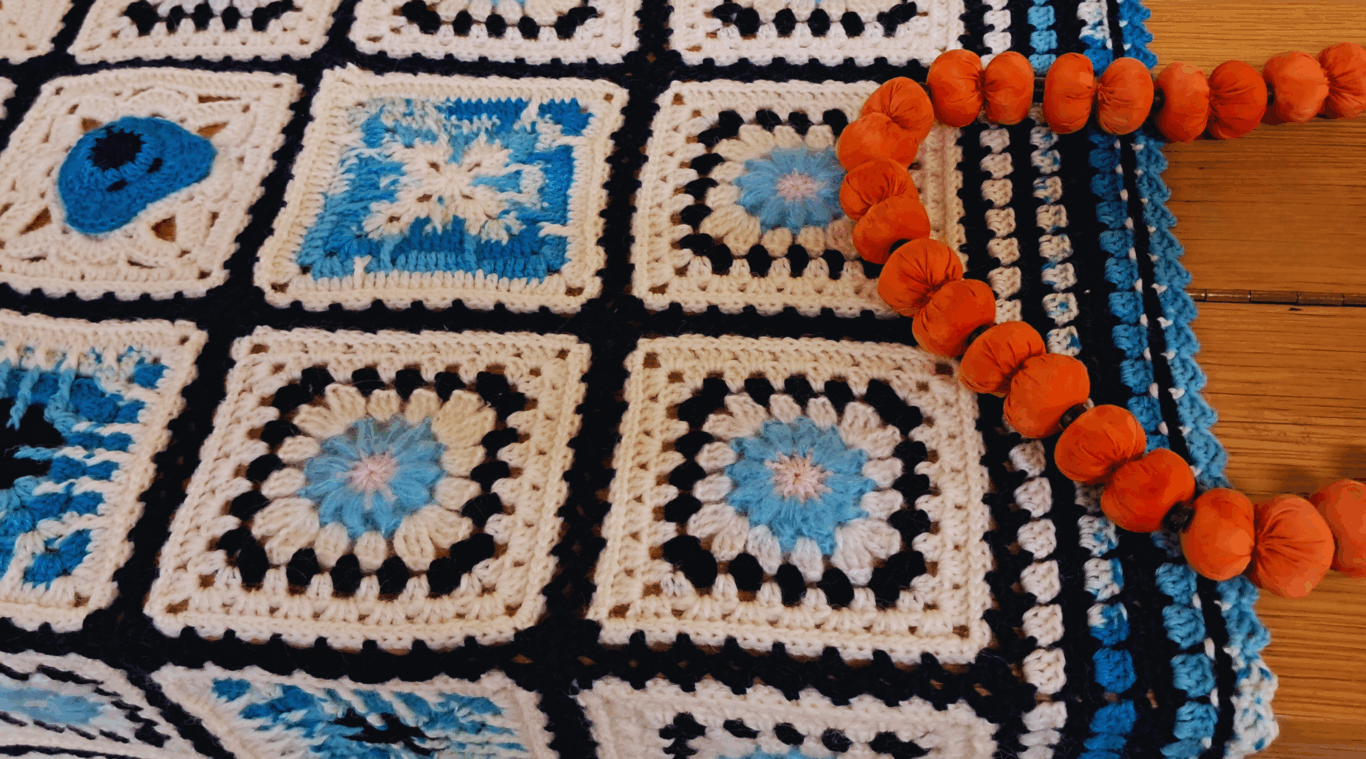 Isoäidinneliöistä koottu peitto ja käsintehty koru. 