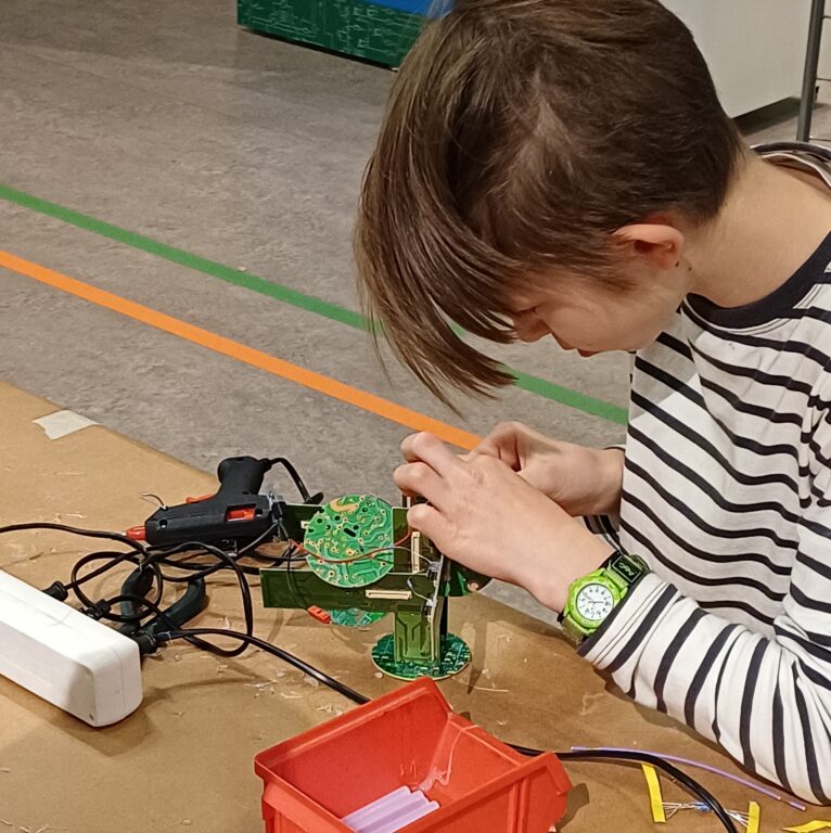 Lapsi rakentaa hahmoa piirilevyn palasista.