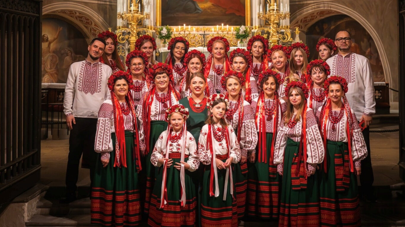 The choir in colorful national costumes in front of Turku Cathedral altar.