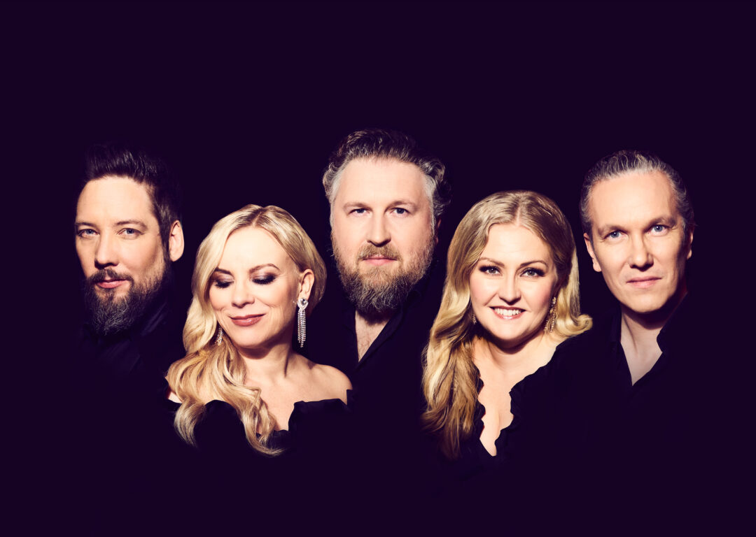 Viisi laulajaa vierekkäin, tumma tausta