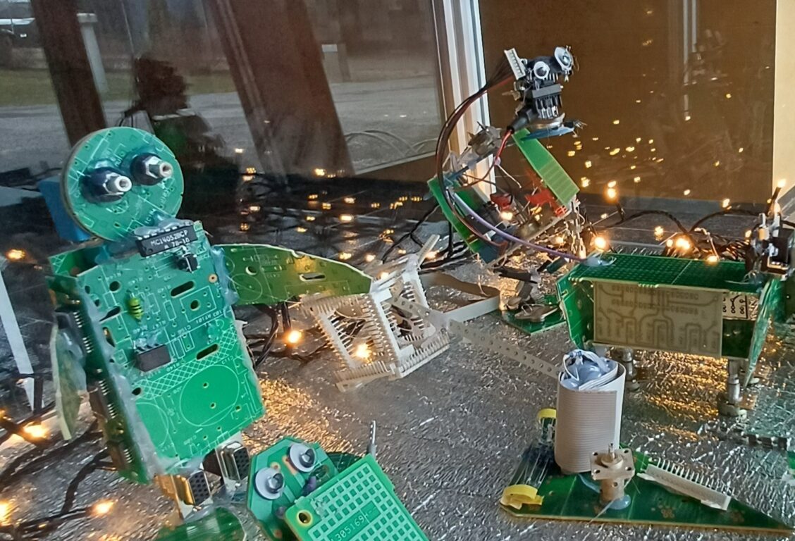 Kokoelma elektroniikkakomponenteista rakennettuja robottihahmoja.