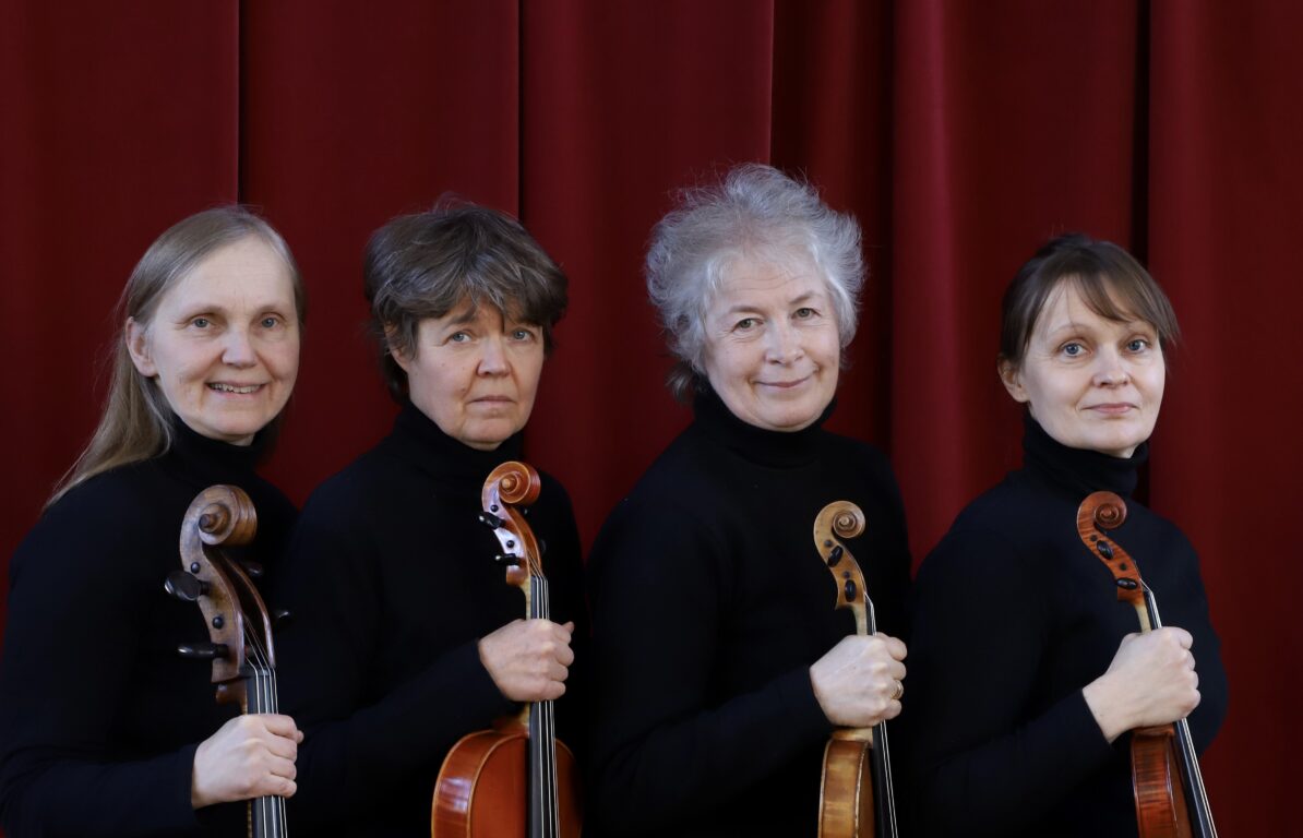 neljä soittajaa rivissä, tumma tausta