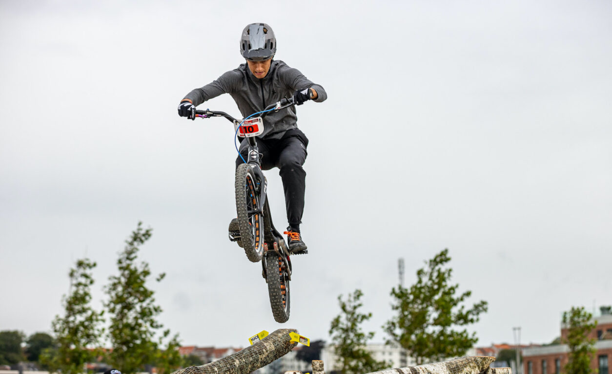 Niilo Stenvall trial-pyöräilijä hyppää pyörällään puunrunkojen yli. Niilo esiintyy Teijo Bike & Outdoor Festeillä. 