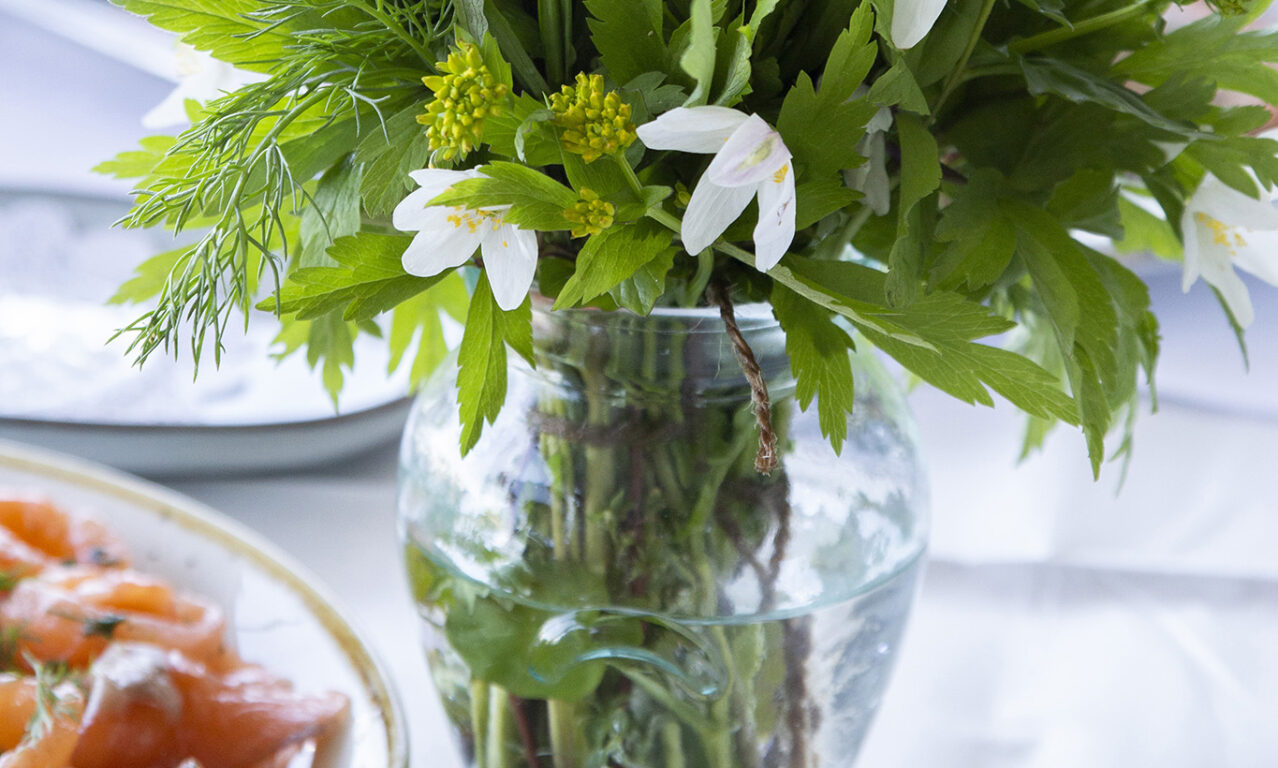 Valkovuokkoja ja ruokaa pöytään katettuna. 