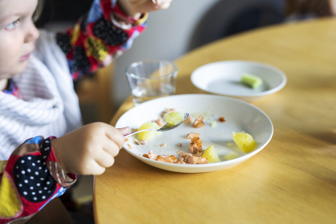 Taapero ruokailemassa pöydän ääressä